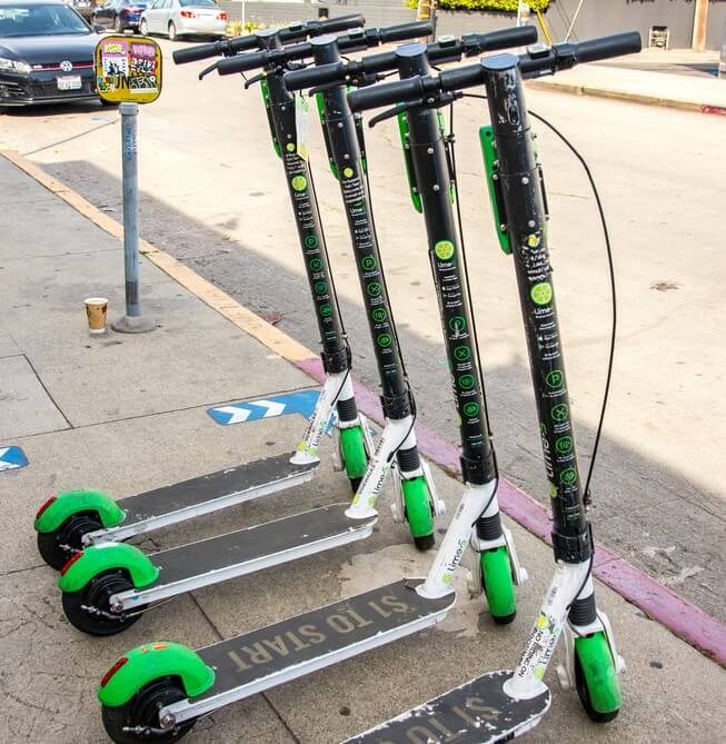 Several lime scooters lined up on side of the road in Los Angeles for rent 
