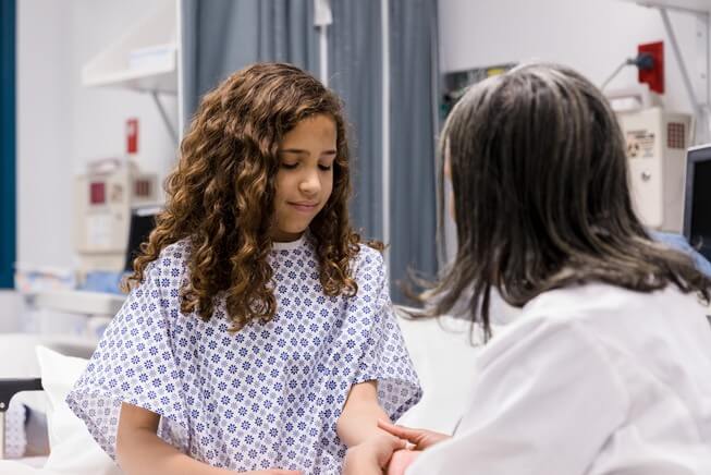 Doctor examines childs arm injury 