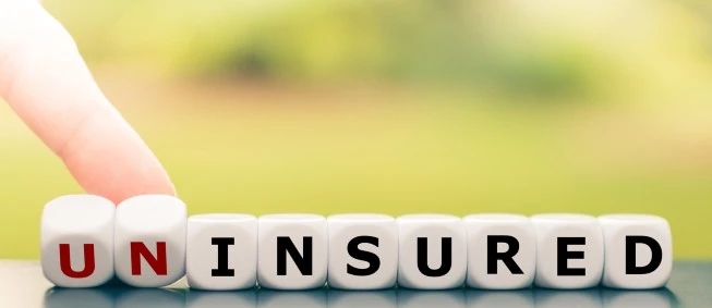 Finger points to letters spelling out uninsured