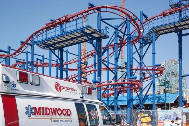 Ambulance parked in front of amusement park 
